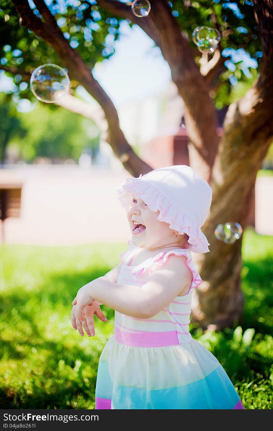 Little girl laughing while playing with soap bubbles. Little girl laughing while playing with soap bubbles