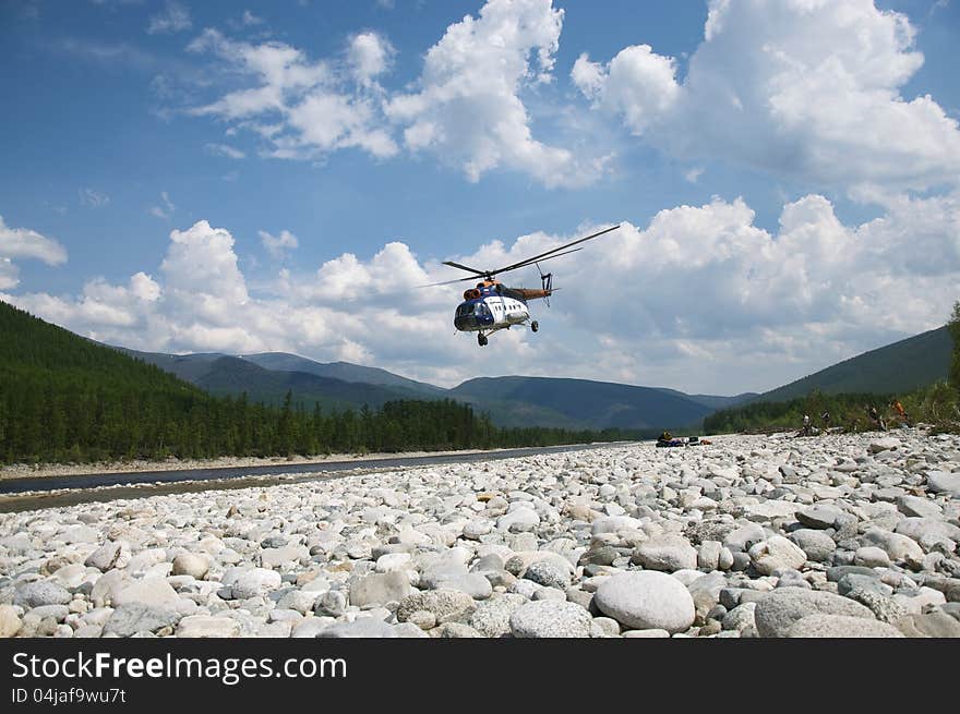 On the river bank the helicopter takes off