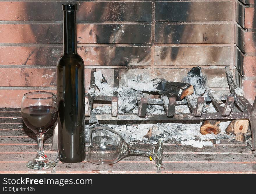 Wineglasses one full and one empty by a dead cold fire. Wineglasses one full and one empty by a dead cold fire