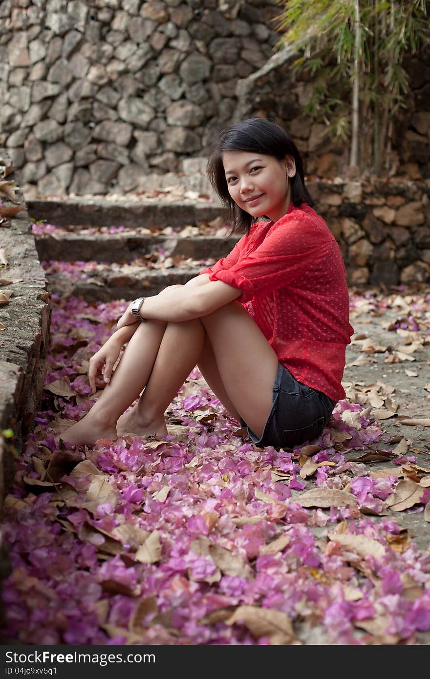 Asian woman sitting on ground with paper flowers