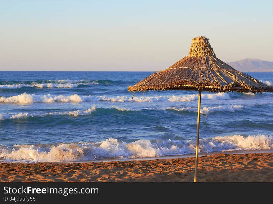 Beach umbrella on sunset near the sea