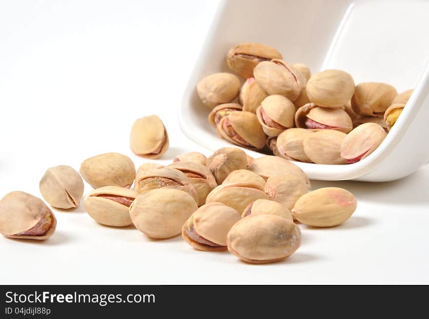 Bowl of Pistachio nuts on isolated white