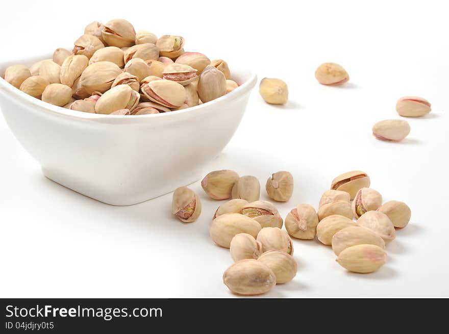 Bowl of Pistachio nuts on isolated white