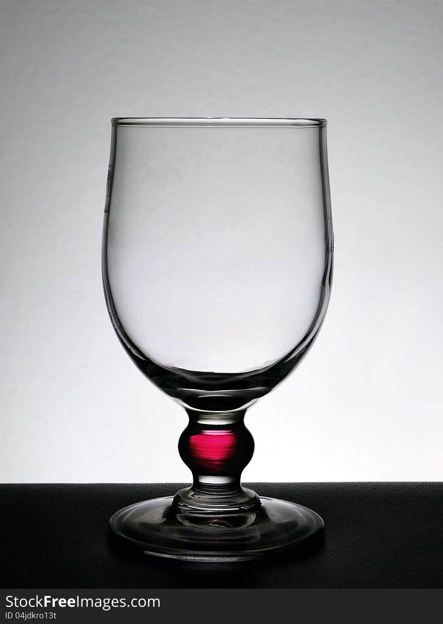 Empty glass on a white background and black base. Empty glass on a white background and black base.