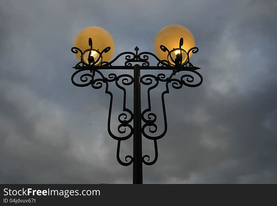 City lamp light at night, and grey sky. City lamp light at night, and grey sky