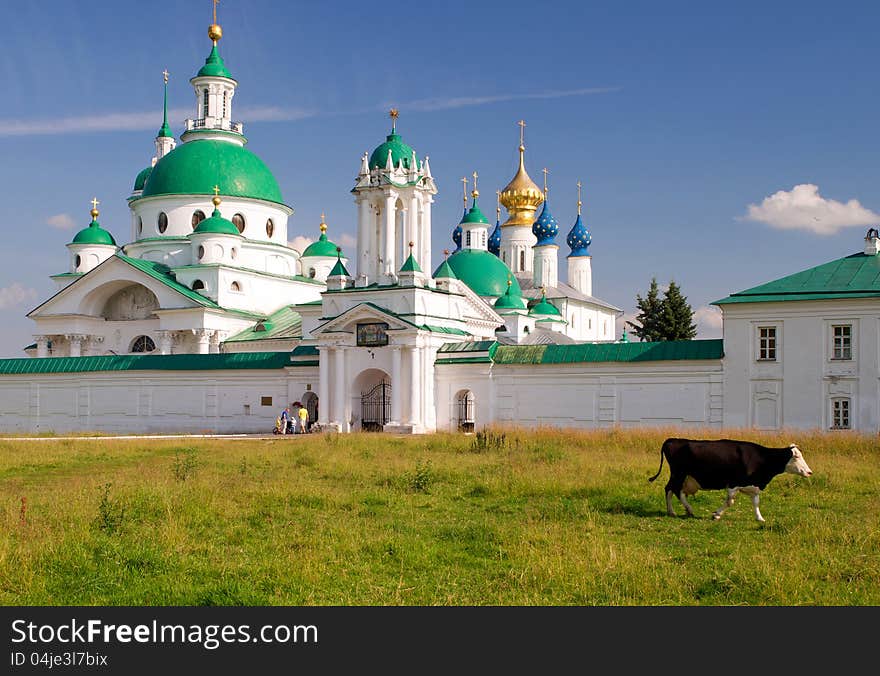 Cow goes past the Spaso-Yakovlevsky Monastery in Rostov the Great, Russia. The ancient town of Rostov the Great is a tourist center of the Golden Ring of Russia. Cow goes past the Spaso-Yakovlevsky Monastery in Rostov the Great, Russia. The ancient town of Rostov the Great is a tourist center of the Golden Ring of Russia.