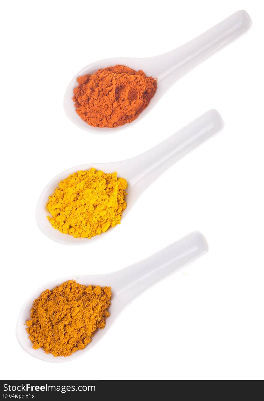 Spices in the spoons on a white background