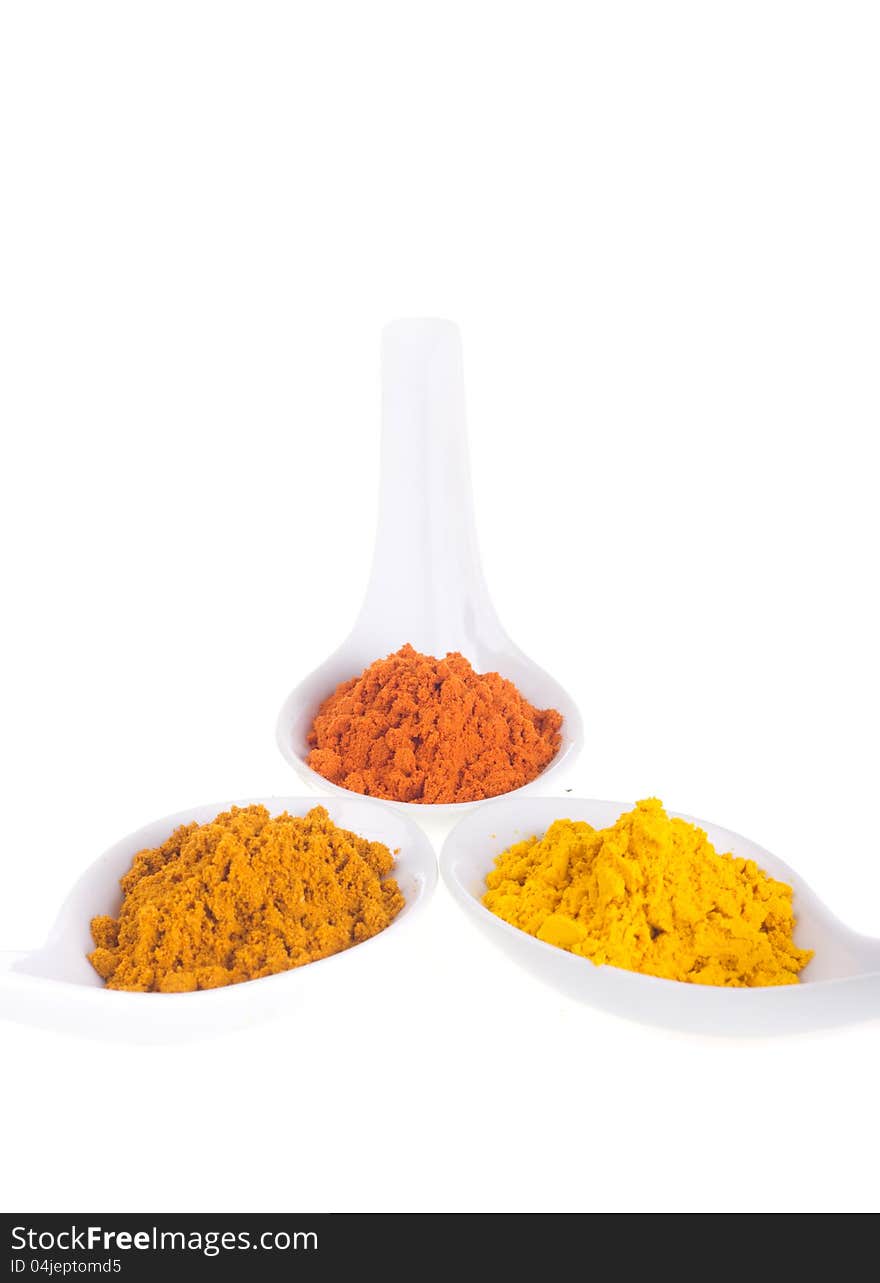 Spices in the spoons on a white background