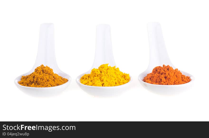 Spices in the spoons on a white background