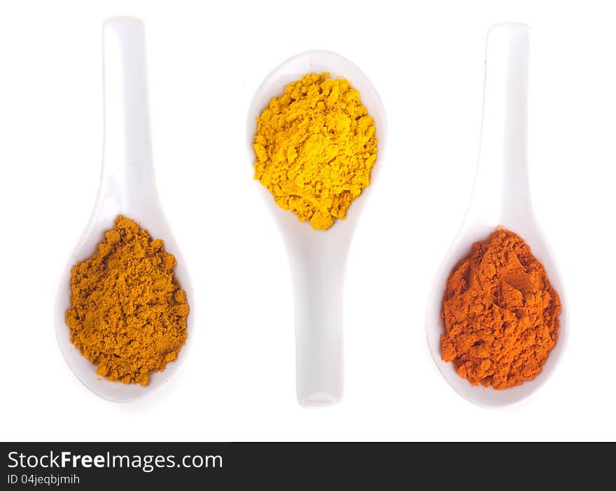 Spices in the spoons on a white background