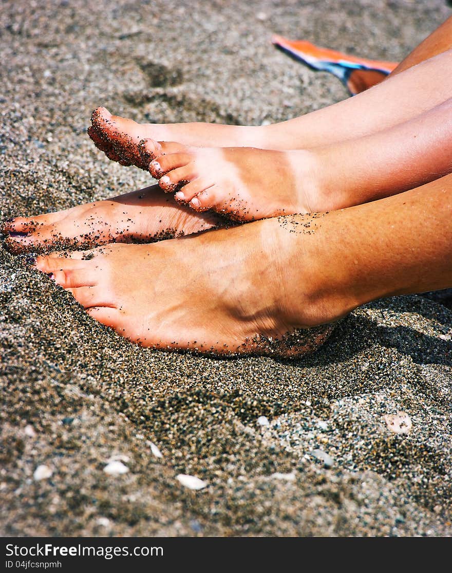 The beautiful female and children's legs made on a beach. The beautiful female and children's legs made on a beach