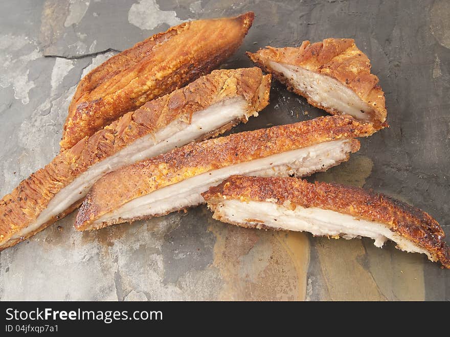 Crispy pork slices against grey