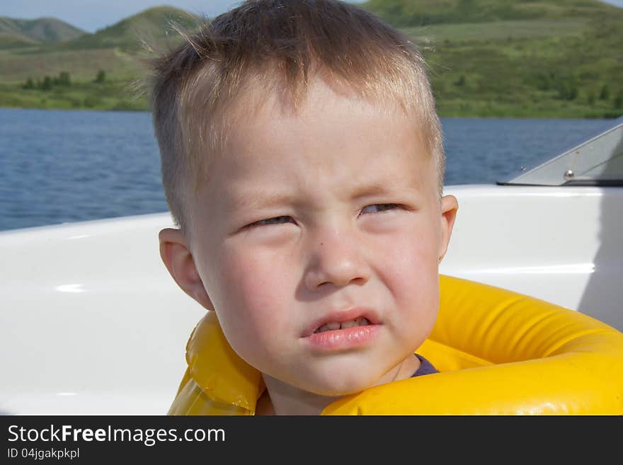 Little boy sitting in the bow of a boat with there life jackets having fun. Little boy sitting in the bow of a boat with there life jackets having fun