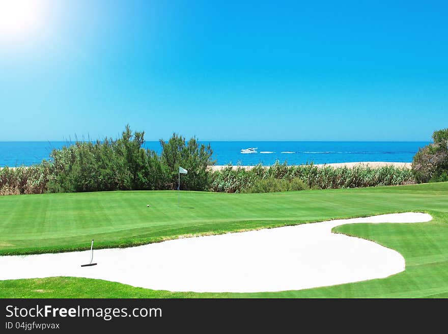 Picture a golf course and the yacht at sea. Portugal.