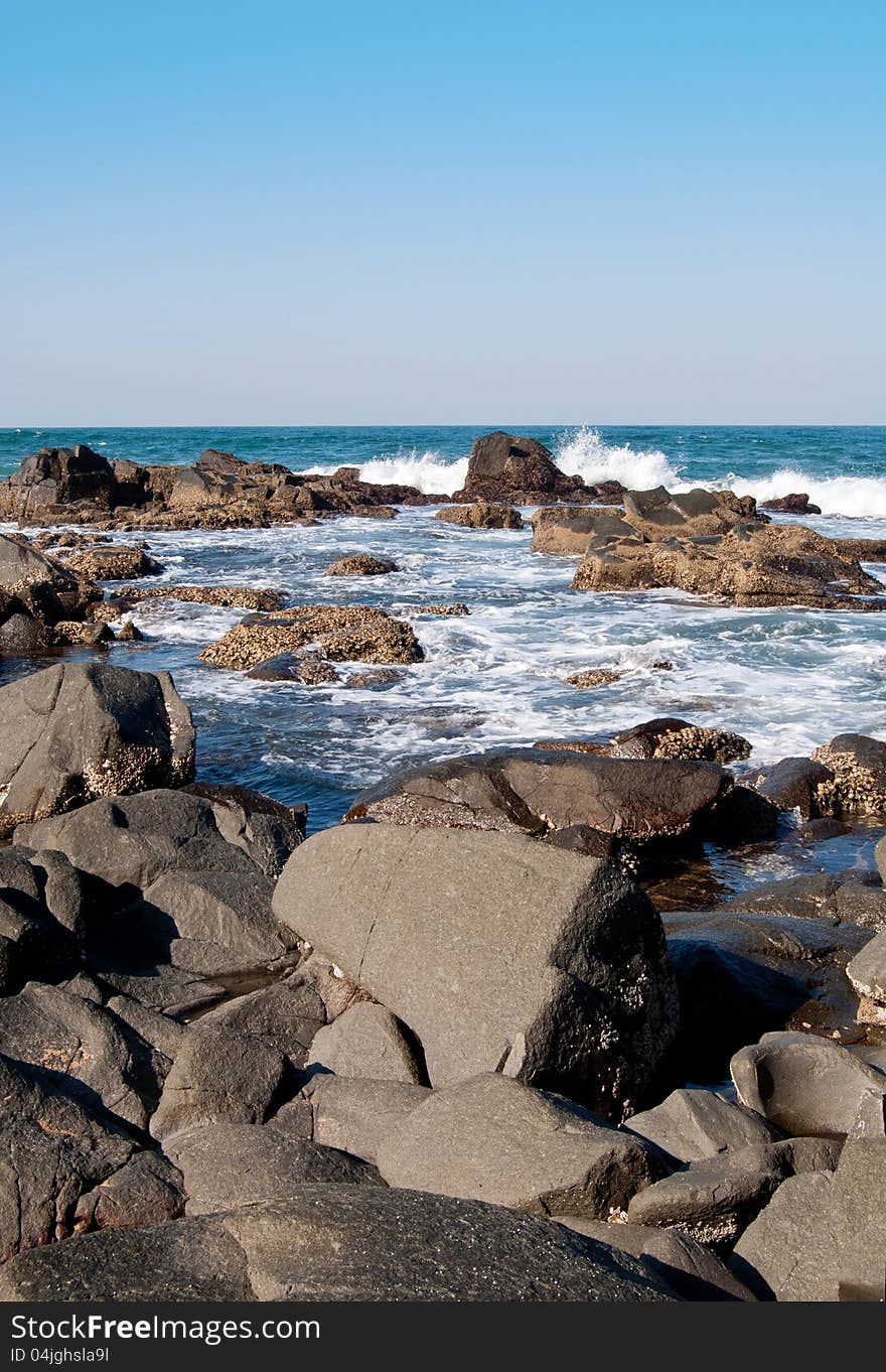 Waves beak and surf swirls around rocks along the rugged coast of Ballito, KwaZulu-Natal North Coast, South Africa. Waves beak and surf swirls around rocks along the rugged coast of Ballito, KwaZulu-Natal North Coast, South Africa.