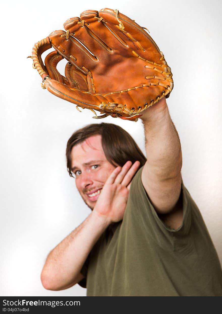 Ball is comming at the guy and he is afraid of it. Has baseball glove up as well as his arm to stop it from hitting his face.Focus is fairly shallow and on the glove though man behind still is enough focus to be usefull. Image isolated against a white background. Ball is comming at the guy and he is afraid of it. Has baseball glove up as well as his arm to stop it from hitting his face.Focus is fairly shallow and on the glove though man behind still is enough focus to be usefull. Image isolated against a white background