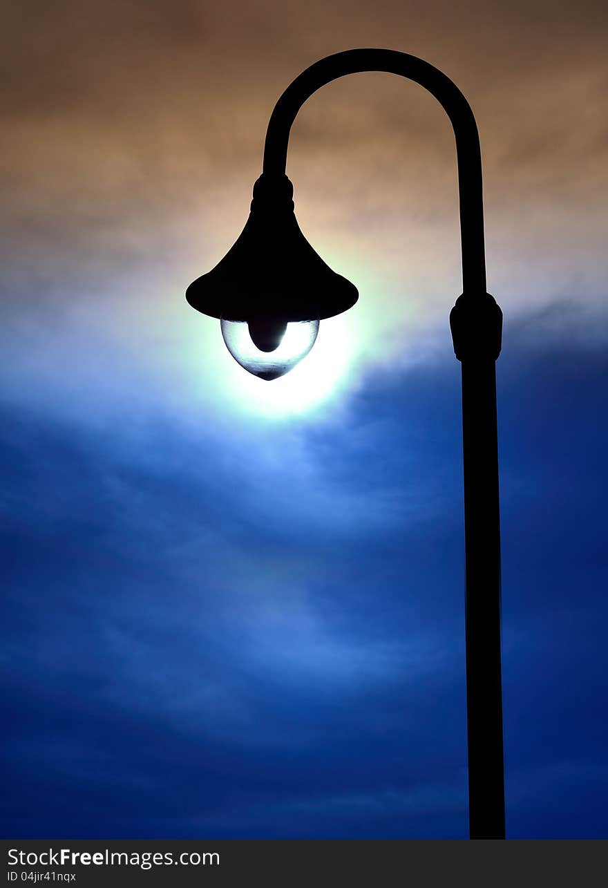 Silhouette street lamps on evening sky