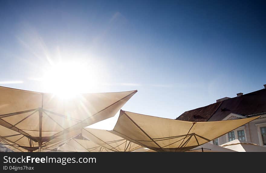 Abstract terrace umbrellas in city and blue sky