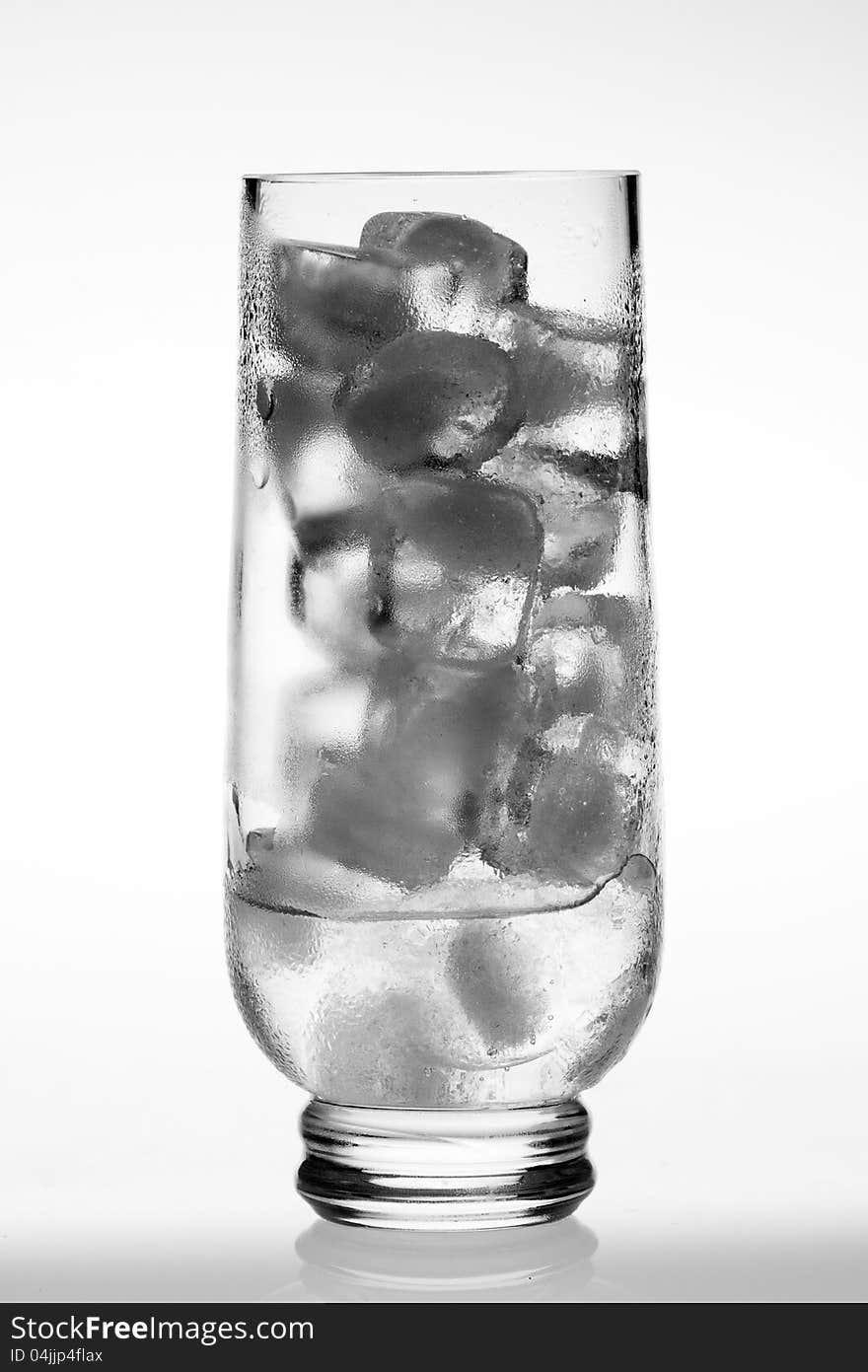 Empty glass with ice cubes on white background