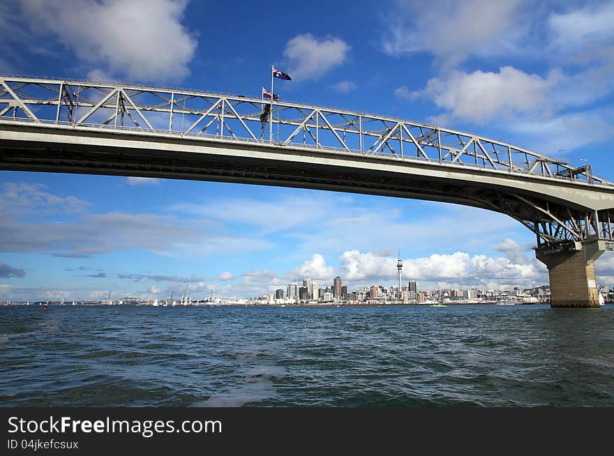 Auckland Harbour Bridge with Auckland City and Sky Tower in the background, New Zealand viewed from the water. Auckland Harbour Bridge with Auckland City and Sky Tower in the background, New Zealand viewed from the water