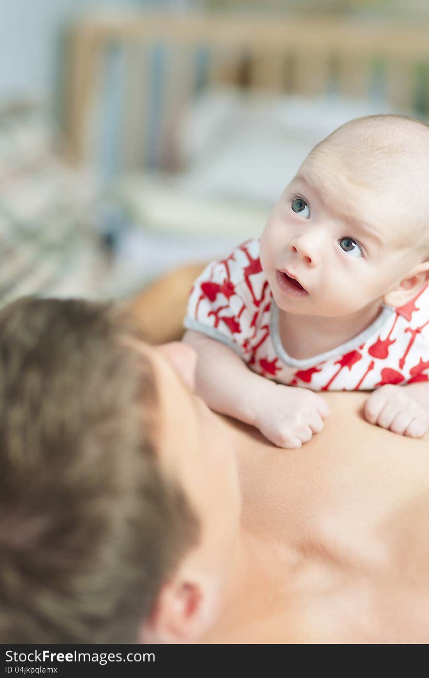 Young caucasian handsome masculine father and his little newborn son communicating together. Young caucasian handsome masculine father and his little newborn son communicating together