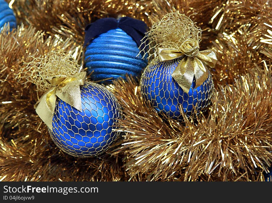 Blue christmas balls on a golden tinsel. Blue christmas balls on a golden tinsel