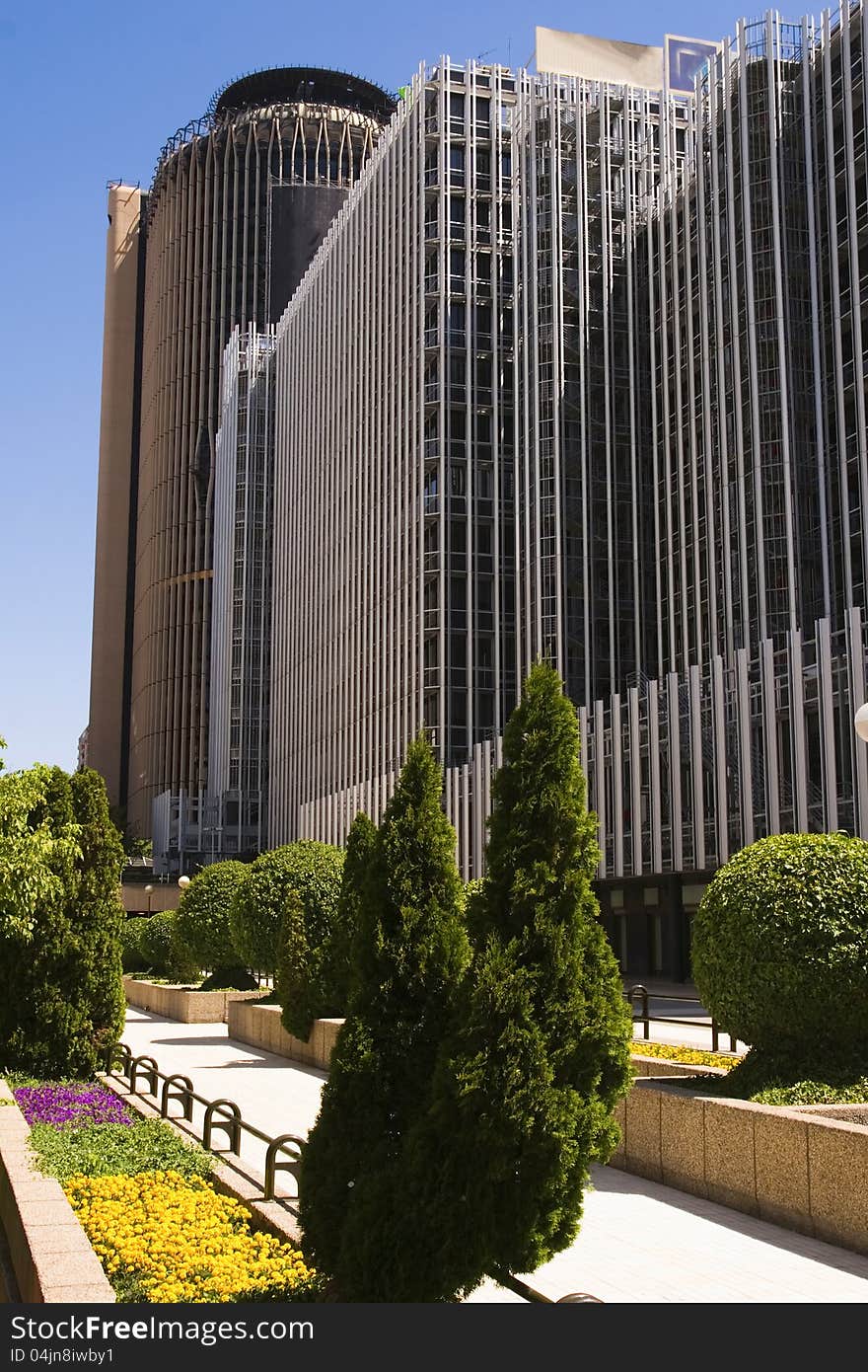 Facade of a building in Azca, Europe Tower in the background, skyscrapers Madrid, Spain. Facade of a building in Azca, Europe Tower in the background, skyscrapers Madrid, Spain