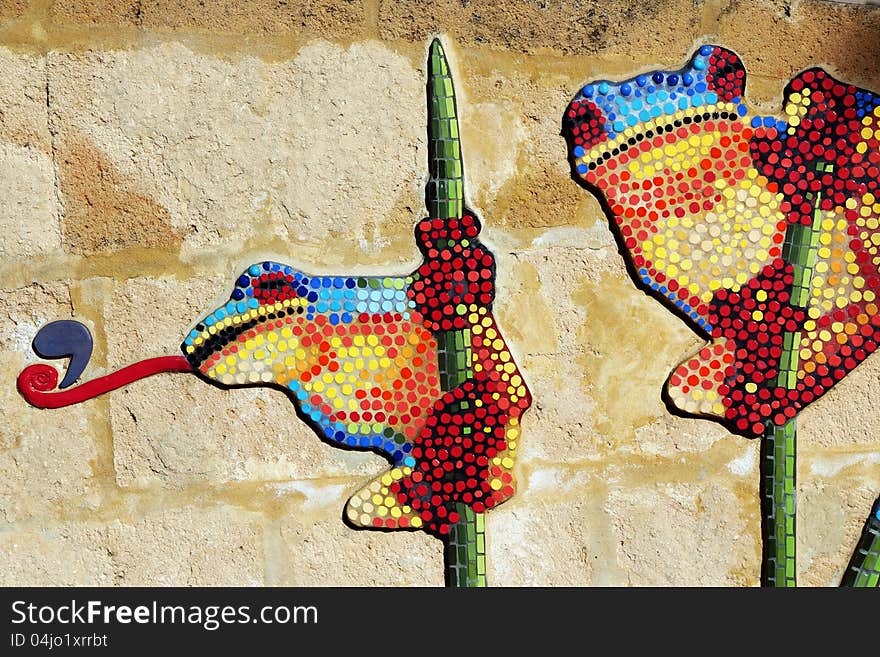 The playful frogs have been painted with dobs of bright colour on a concrete wall in a children's playground and are delightful. The playful frogs have been painted with dobs of bright colour on a concrete wall in a children's playground and are delightful.