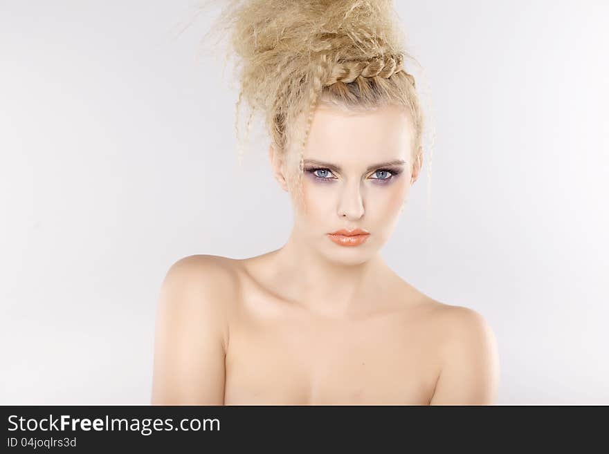 Young pretty woman with beautiful blond hairs and multicolor makeup on white background