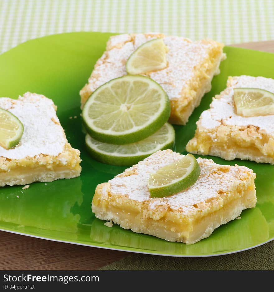 Lime bars on a platter with sliced lime. Lime bars on a platter with sliced lime