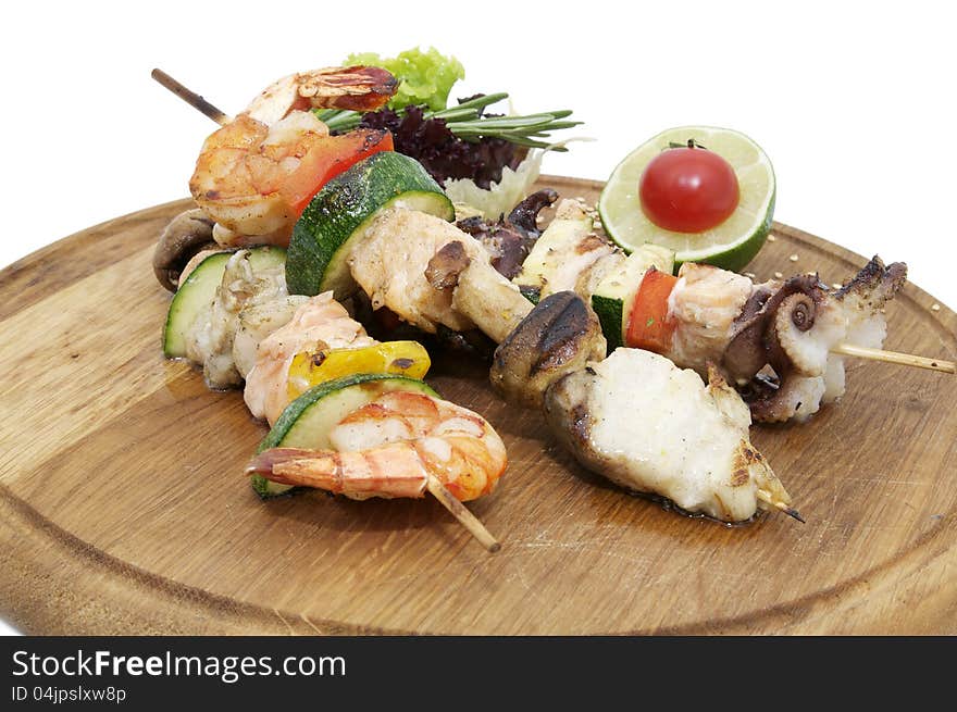 Skewers of seafood on a wooden platter in a restaurant