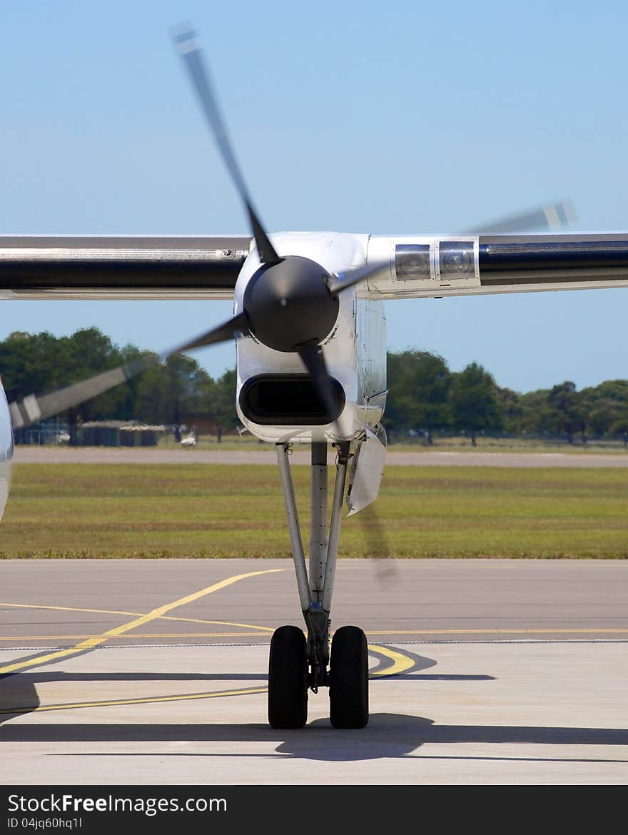 A shot of a turbo prop propeller, taken on the runway of an airport. Blue sky