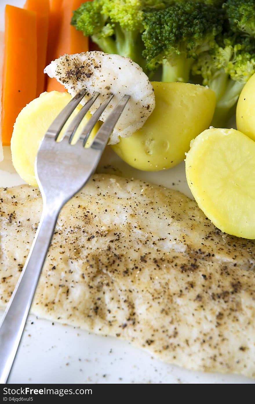 Baked fish on fork put on variety vegetables. Baked fish on fork put on variety vegetables