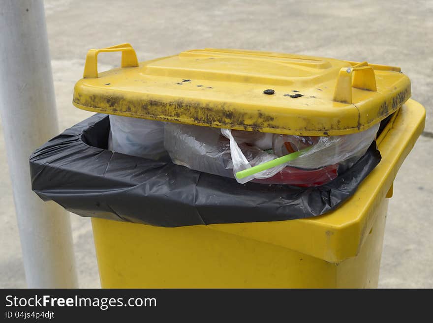 Close up of yellow full trash can