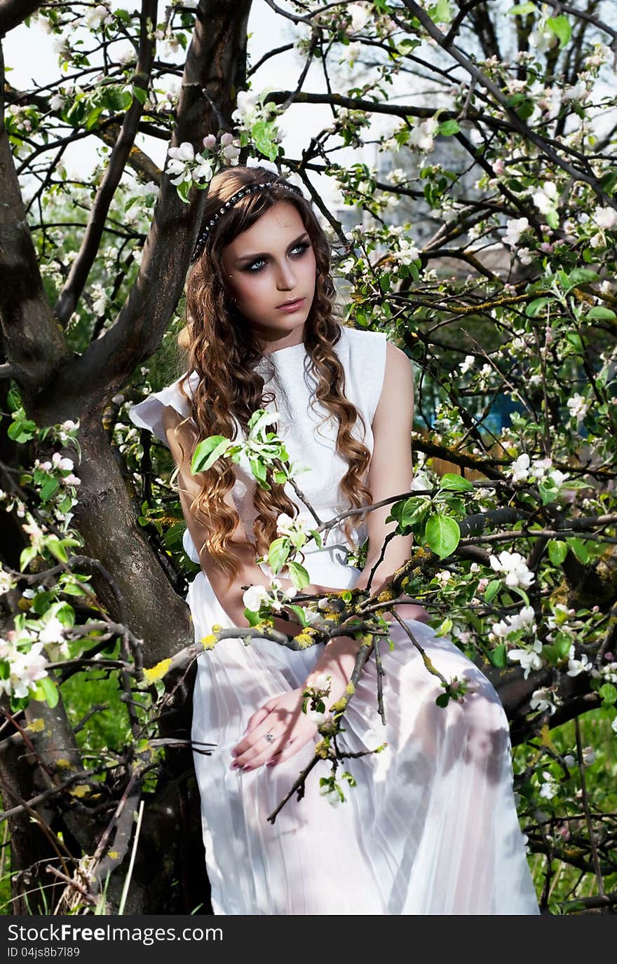 Portrait of young woman bride in the spring flowering garden among trees. Portrait of young woman bride in the spring flowering garden among trees