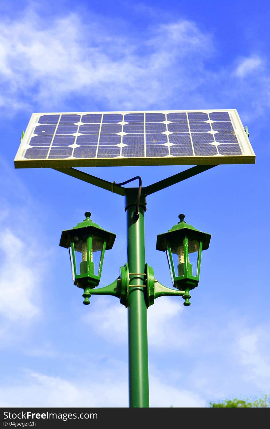 Image of a solar panel giving power to a park lamp