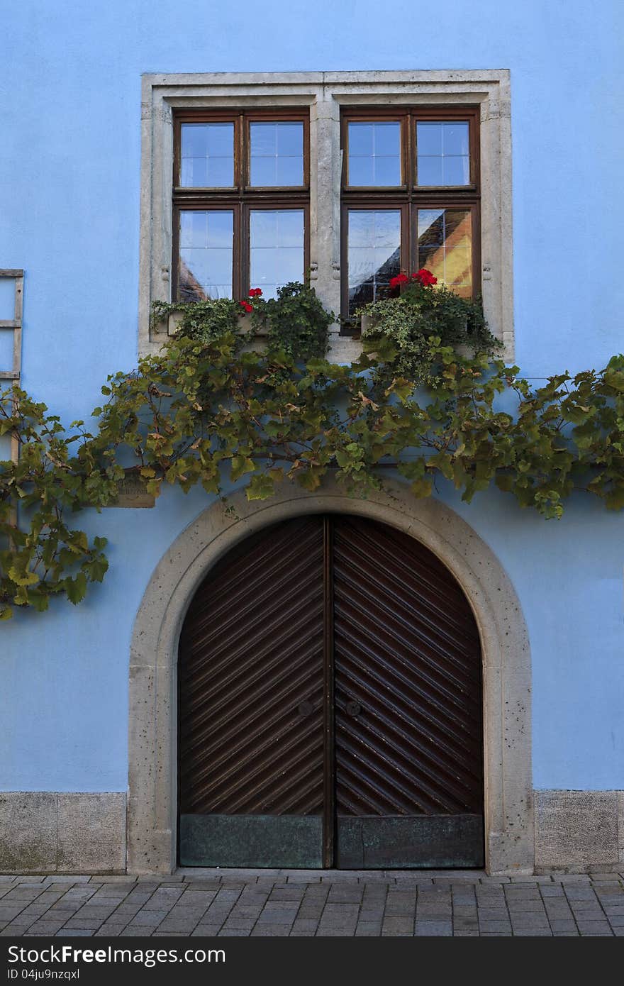 Shuttered windows with trellis of vines above and on the sides of a German house. Shuttered windows with trellis of vines above and on the sides of a German house.