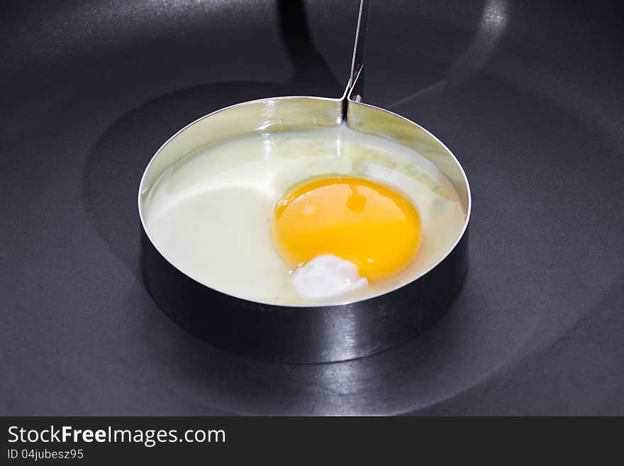 Cooking sunny side up (fried egg) in circle shape on black skillet. Cooking sunny side up (fried egg) in circle shape on black skillet