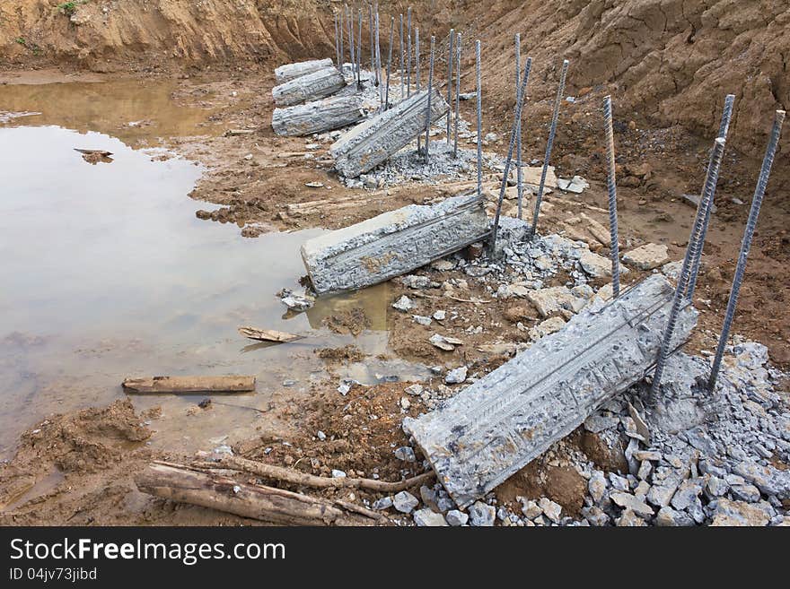 Breaking down concrete piles embedded into the soil to be prepared for a long iron rod. Breaking down concrete piles embedded into the soil to be prepared for a long iron rod.