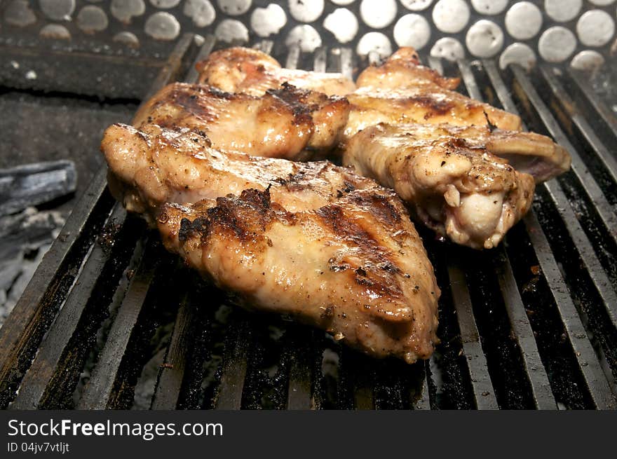 Cooking chicken wings on a grill in the restaurant. Cooking chicken wings on a grill in the restaurant