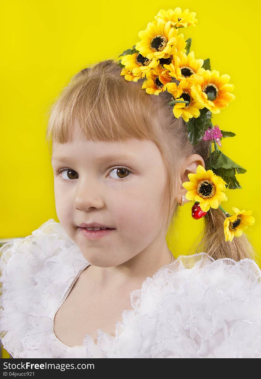 The little girl with yellow flowers in hair. Yellow isolated.