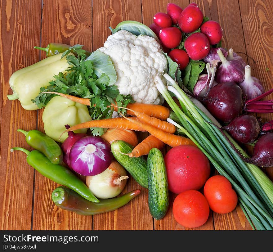 Fresh Raw Vegetables with Cabbage, Peppers, Carrot, Radish, Onion, Tomatos and Garlic on wooden background