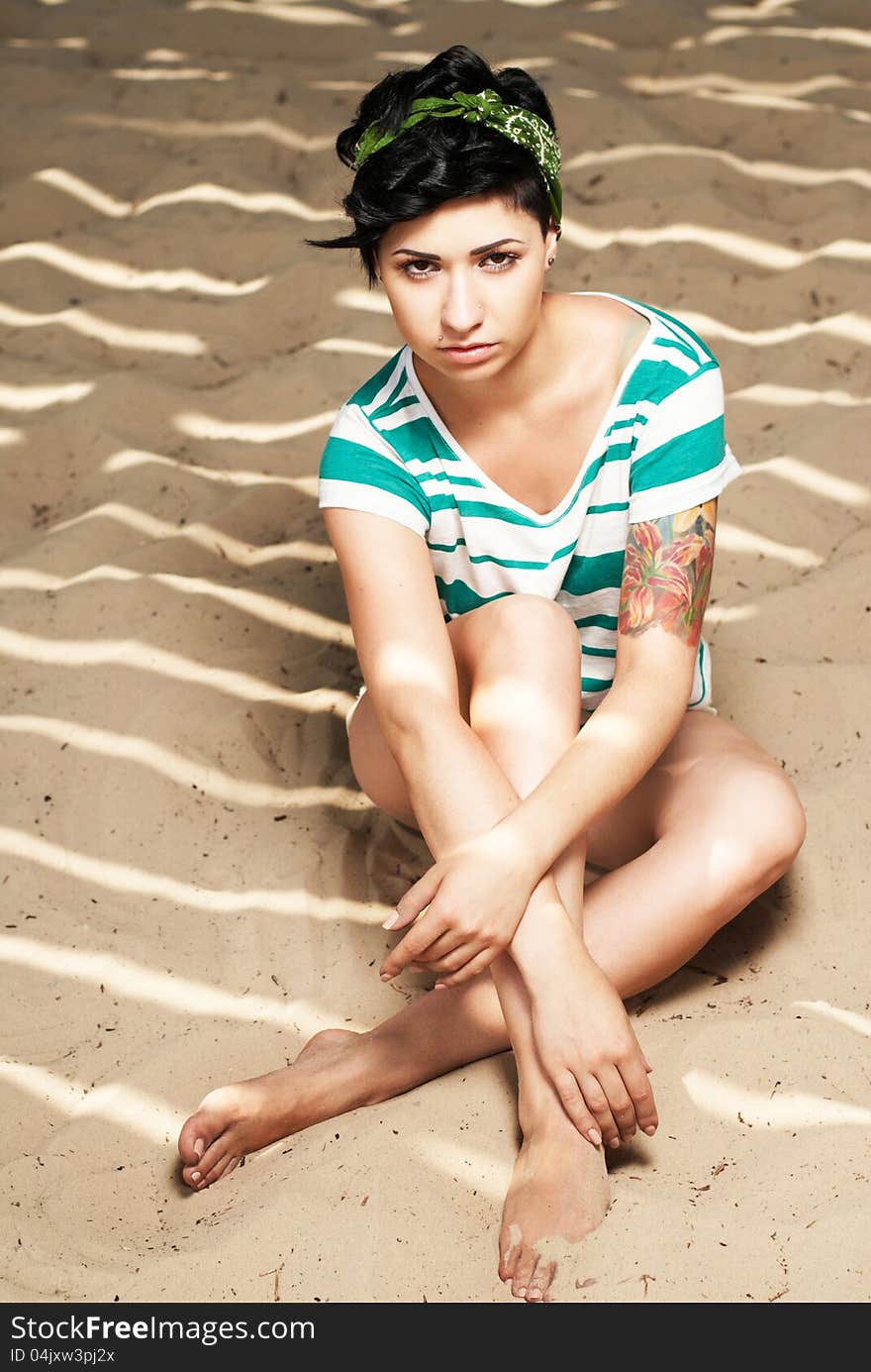 Adorable girl with tattoo on the beach