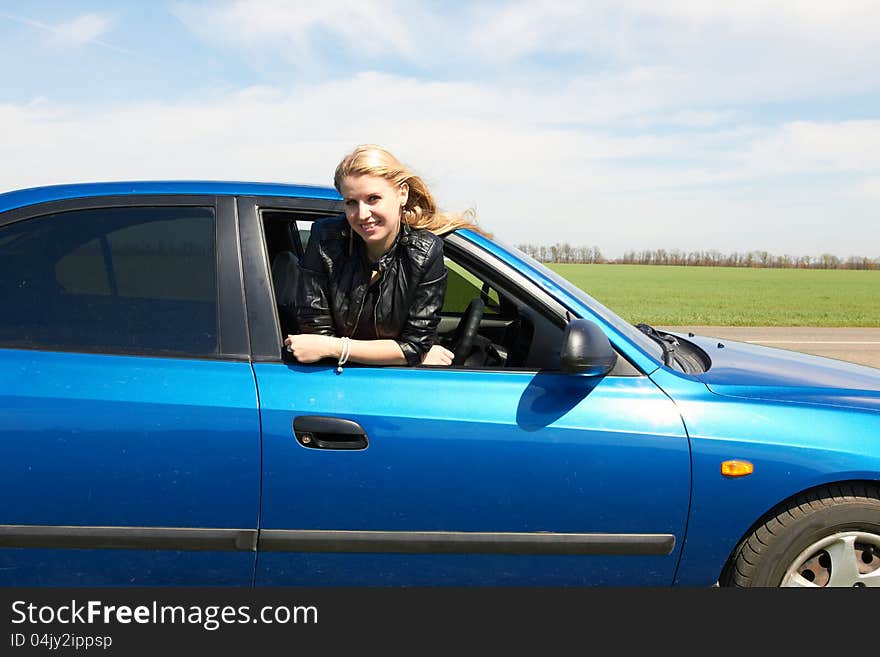 Happy girl in the dark blue car. Happy girl in the dark blue car