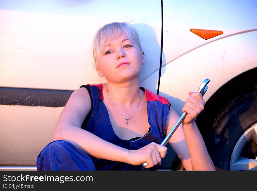 Beautiful young woman repairing the car