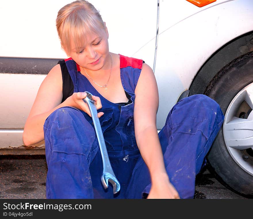 Beautiful young woman repairing the car