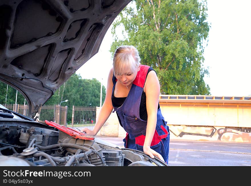 Beautiful young woman repairing the car