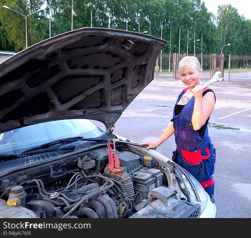 Beautiful young woman repairing the car