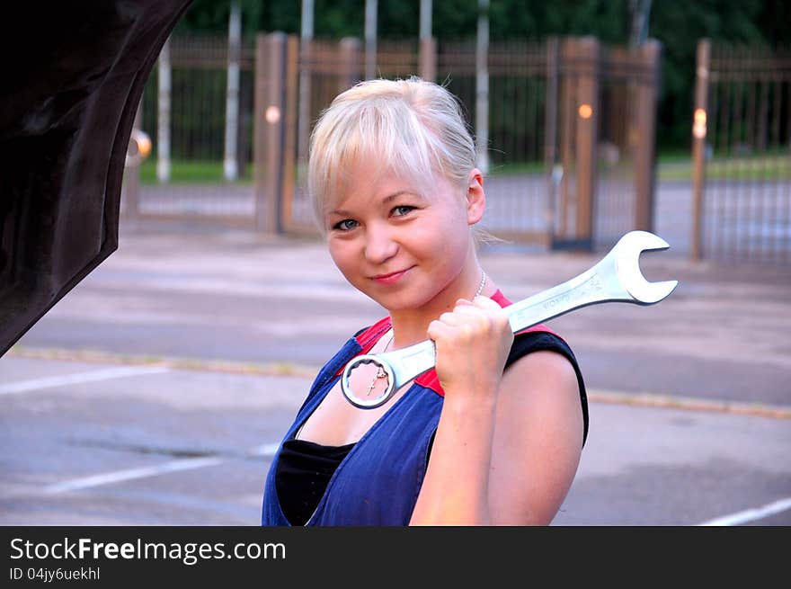 Beautiful young woman repairing the car