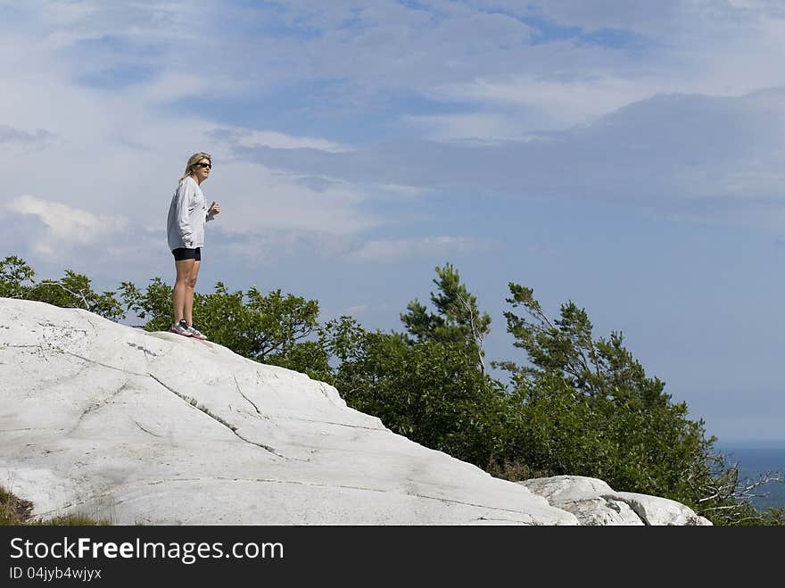 A Woman Stands High Above the Wilderness.